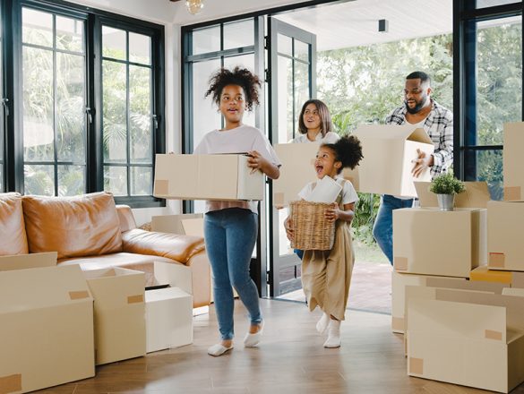 Happy African American young family bought new house. Mom, Dad, Happy African American young family bought new house. Mom, Dad, and child smiling happy hold cardboard boxes for move object walking into big modern home. New real estate dwelling, loan and mortgage.